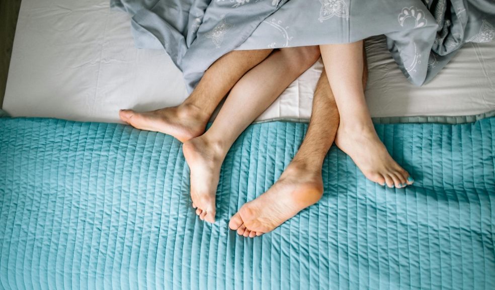 The legs of a couple in bed together