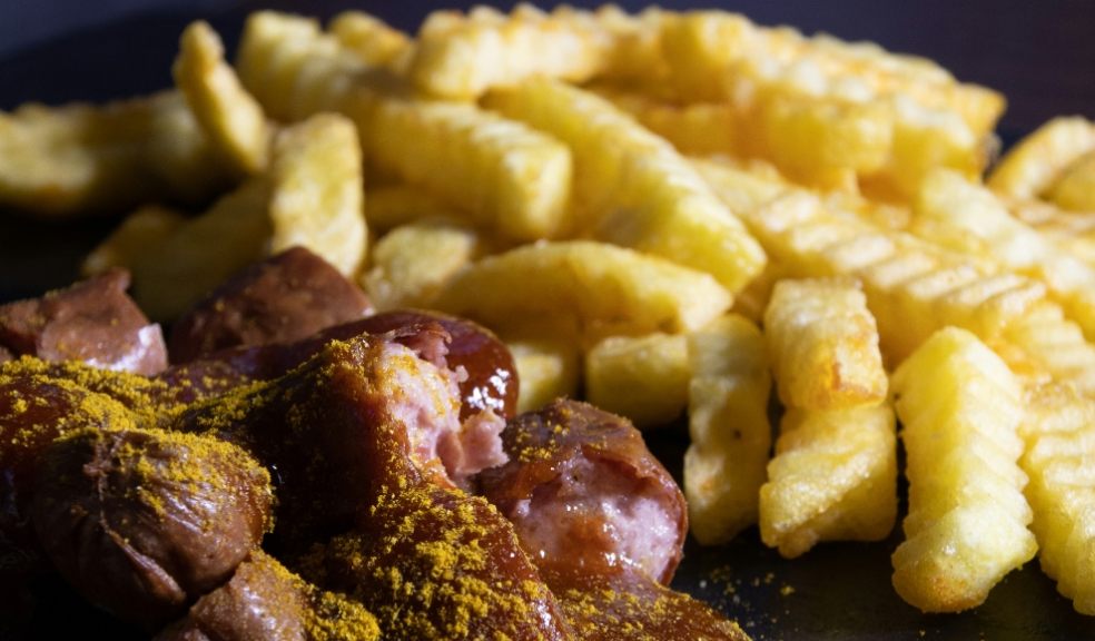 A photograph showing currywurst and fries
