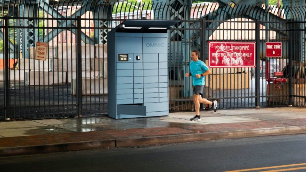 photo of a man running past  a parcel locker in the street