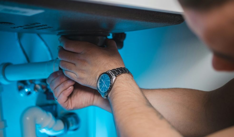 A plumber working under a sink