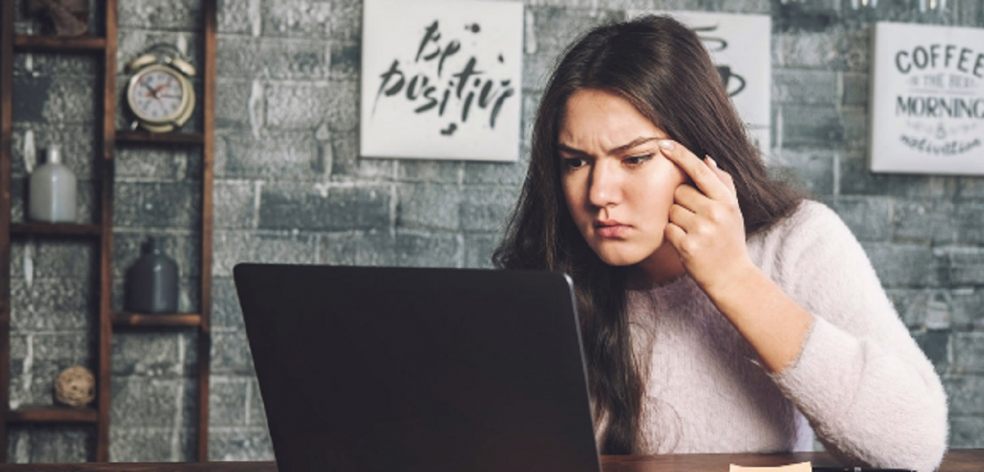 Teen girl squinting whilst looking at computer screen