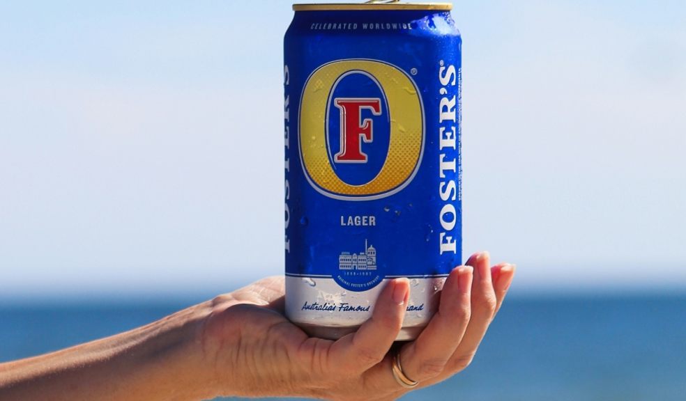 Foster's has been named as the top drink this summer A can of beer being held in front of a beach