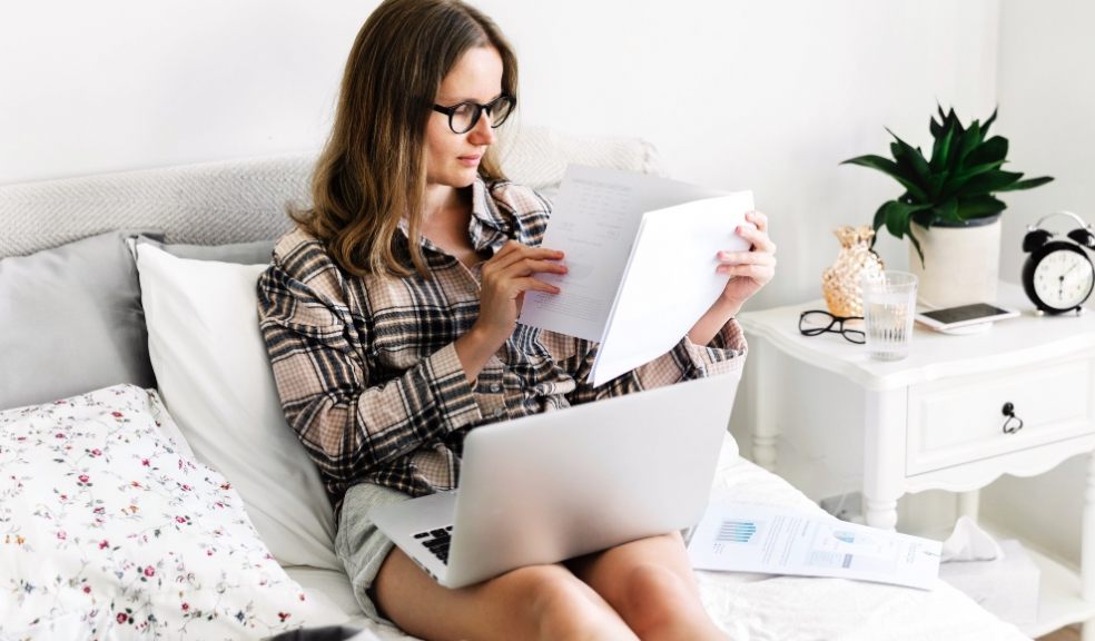 Woman working at home on laptop in bedroom. Lifestyle