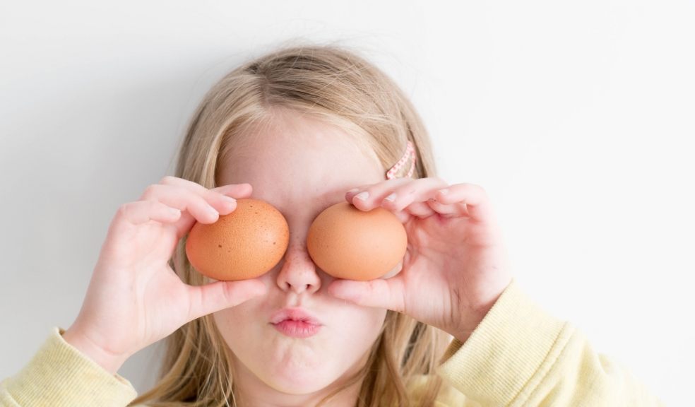 Young girl preparing to cook for her family with eggs.