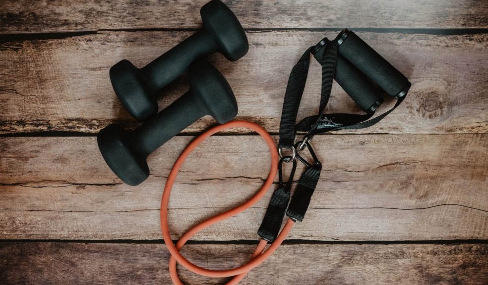 Dumbells and Resistance bands on a hardwood floor