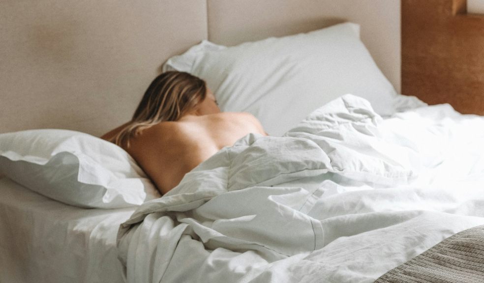 A woman half naked in bed