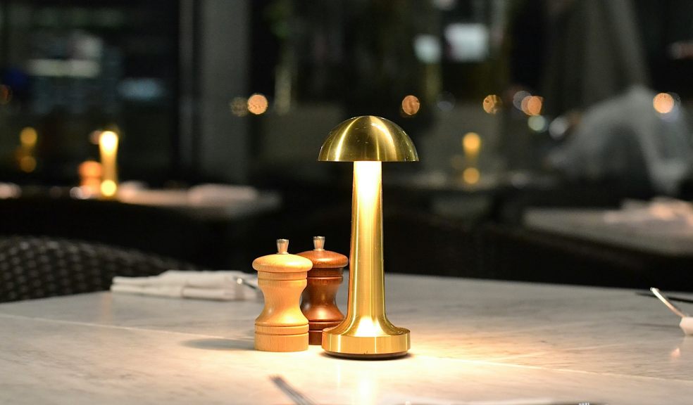 A golden lamp lights up a restaurant table during winter