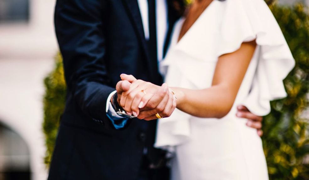 Newlywed couple holding hands