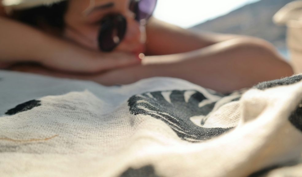 Experts have issues a warning ahead of the hot weather A woman sunbathing win the beach