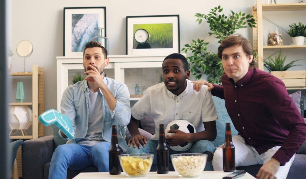 Men watching a football fame on TV