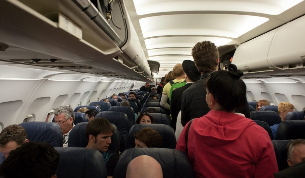 Passengers standing in the aisle of a plane