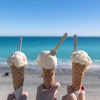 Ice cream cones at the beach Three ice cream cones being held up near the beach