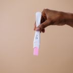 Lifestyle changes can help your chances of conceiving A woman's hand holding a positive pregnancy test on a neutral background