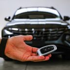 There are many factors to consider when buying a new car A man holding a key in front of a new car