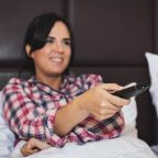 World Cup sleep plan A woman in bed with a remote control