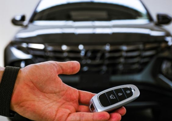 There are many factors to consider when buying a new car A man holding a key in front of a new car