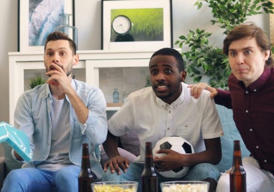 Men watching a football fame on TV
