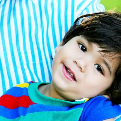 Happy toddler with cerebral palsy in his father's arms