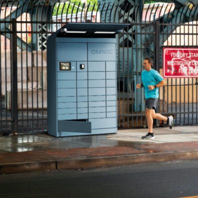 photo of a man running past  a parcel locker in the street