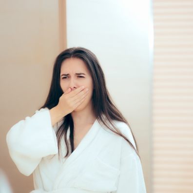 Woman in robe feeling tired after not enough sleep