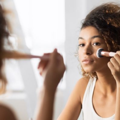 lady in mirror applying makeup