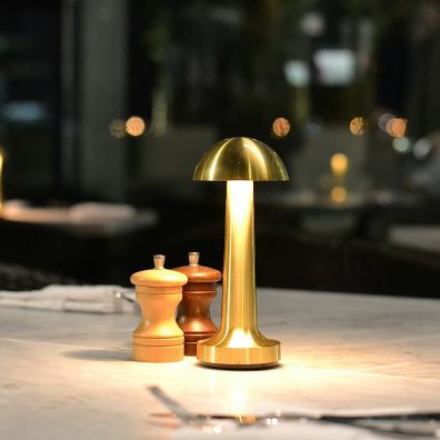 A golden lamp lights up a restaurant table during winter