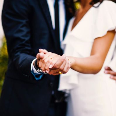 Newlywed couple holding hands