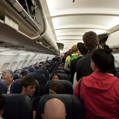 Passengers standing in the aisle of a plane